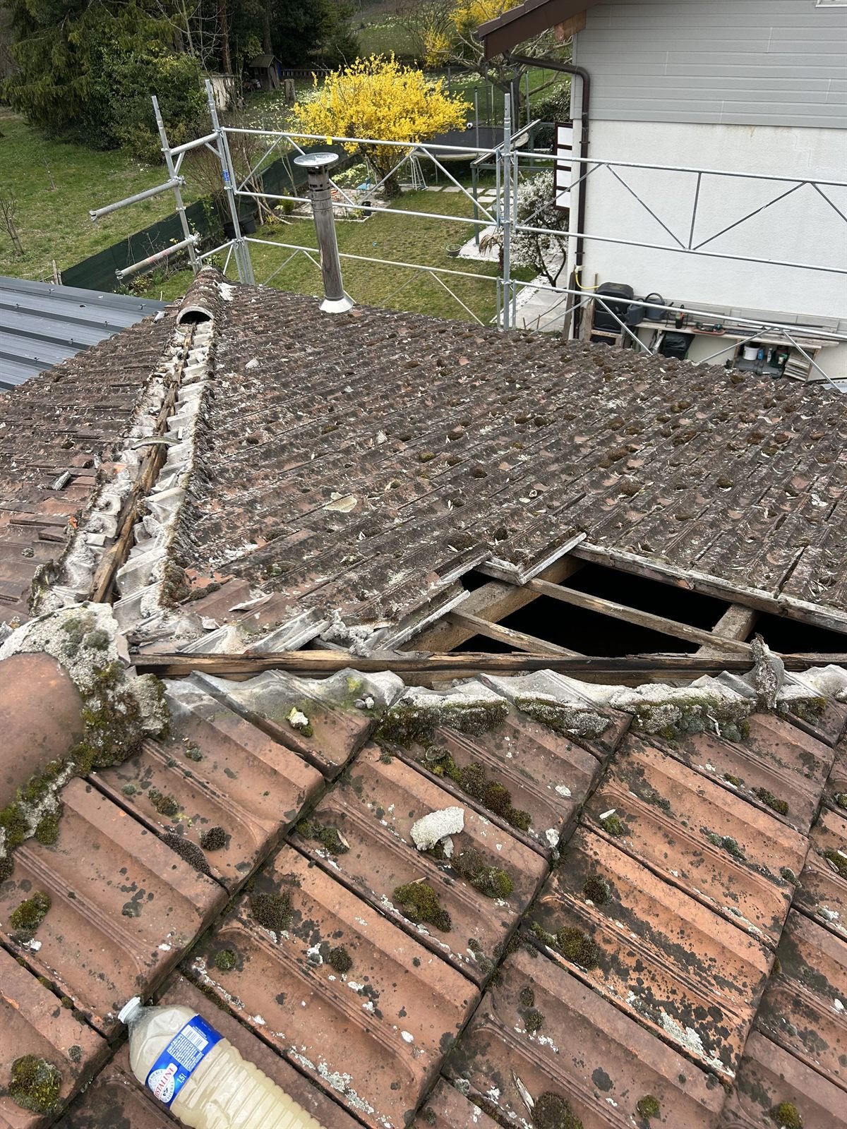 Réparation d'une toiture endommagée avec tuiles cassées dans les Hautes-Alpes